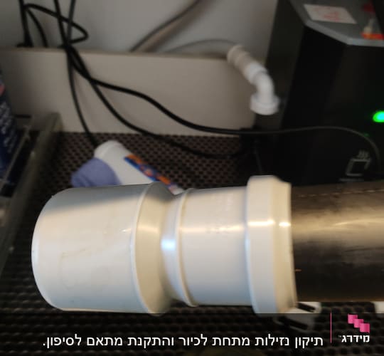 צינור פלסטיק מתחת לכיור עם חיבורים